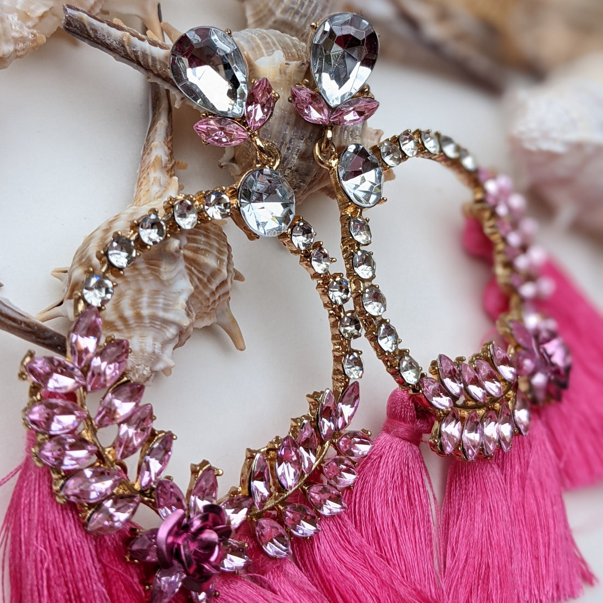 Introducing our Radiance Statement Earrings – a bold and breathtaking earring available in Red, Yellow, Green, and Pink! These eye-catching earrings feature sparkling crystal-studded hoops, vibrant gemstone embellishments, and elegant silk tassels that add a touch of movement and drama. Designed for the fearless fashionista whether you choose fiery red, sunshine yellow, emerald green, or blush pink, each color is crafted to make a stunning statement.