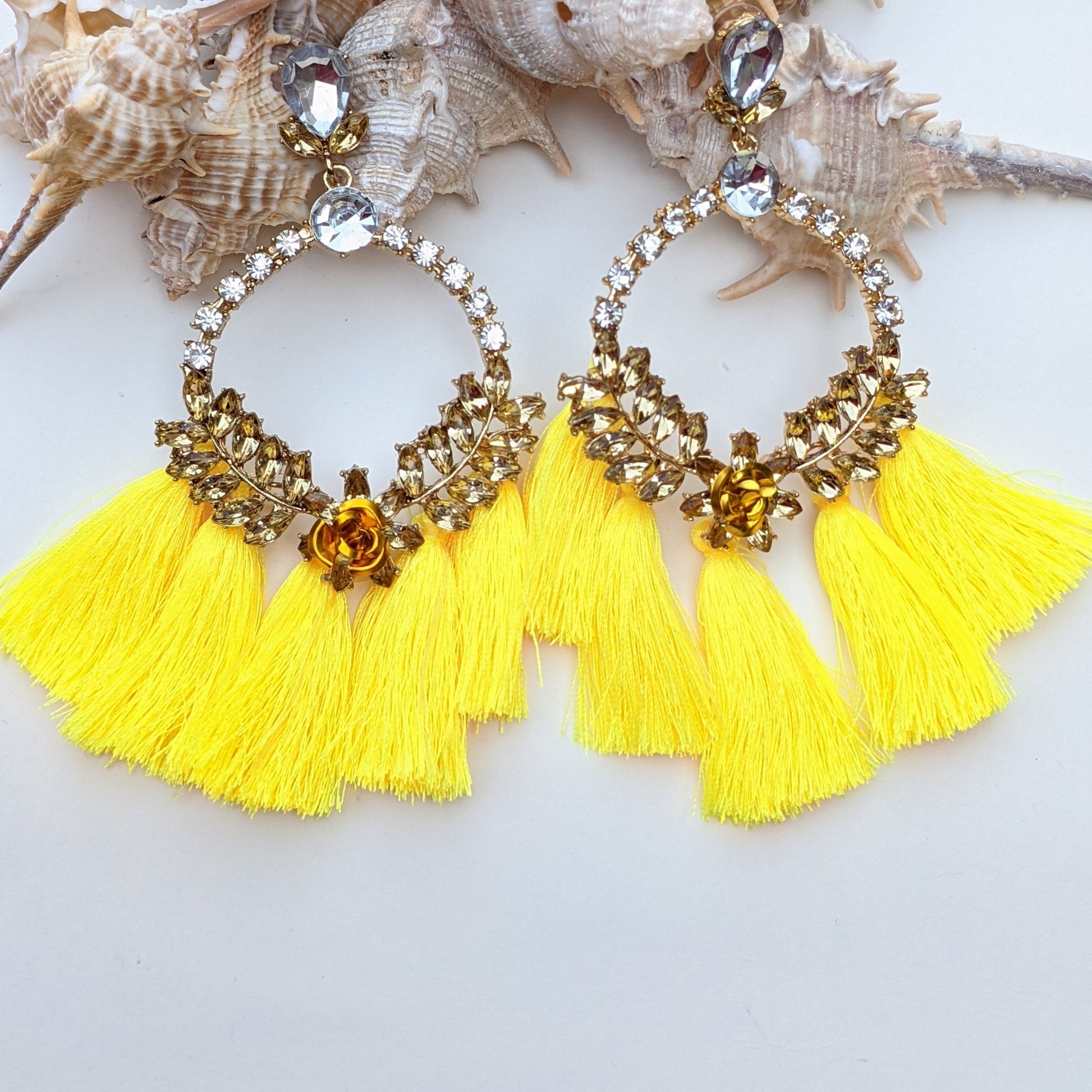 Introducing our Radiance Statement Earrings – a bold and breathtaking earring available in Red, Yellow, Green, and Pink! These eye-catching earrings feature sparkling crystal-studded hoops, vibrant gemstone embellishments, and elegant silk tassels that add a touch of movement and drama. Designed for the fearless fashionista whether you choose fiery red, sunshine yellow, emerald green, or blush pink, each color is crafted to make a stunning statement.